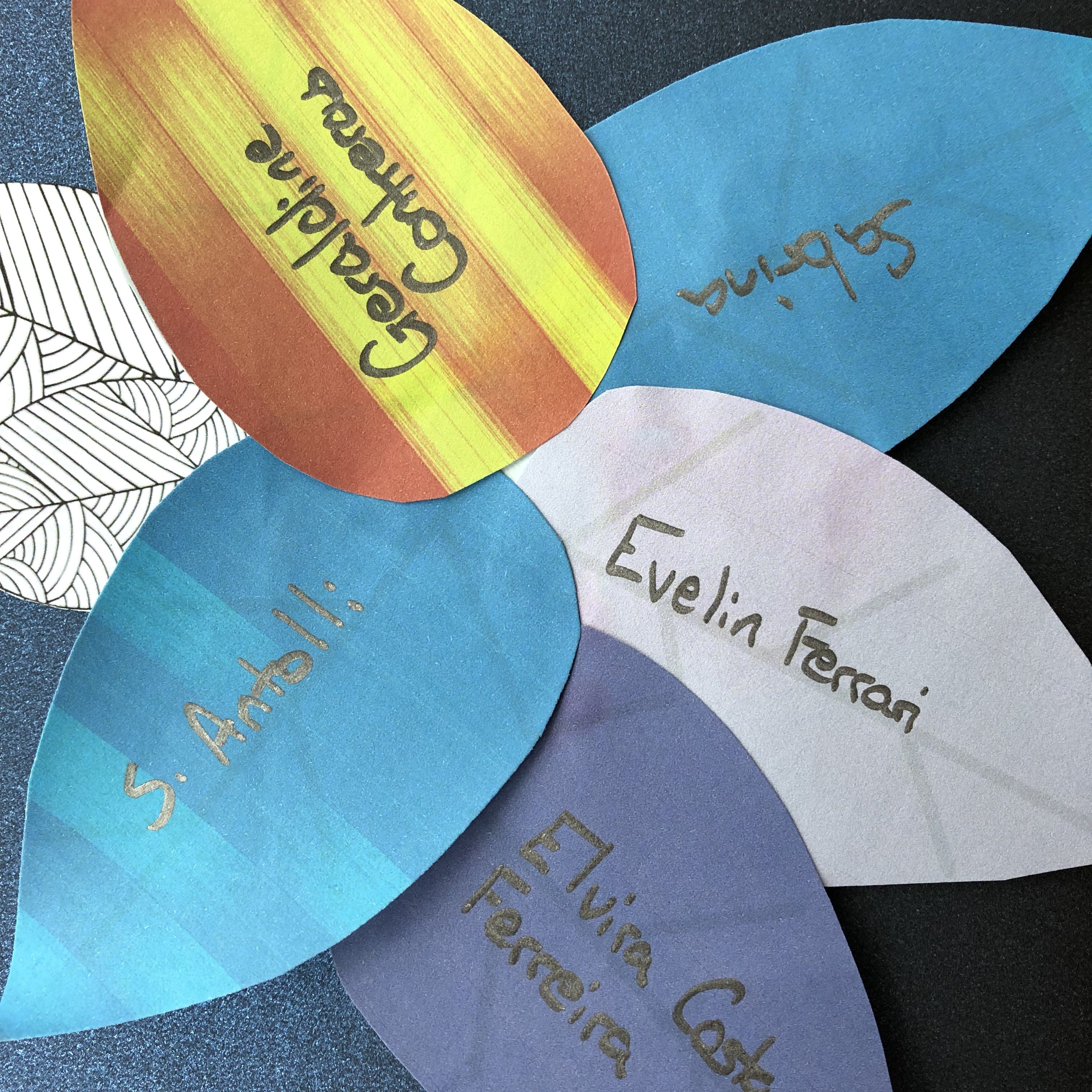 Cluster of six multicoloured paper leaves representing trans people who died in the last year