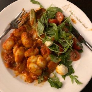 Gnocchi in a tomato sauce with mozzarella, tomato and basil salad on a Grand Central Hotel plate